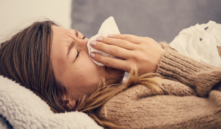 Woman with spring allergies laying down at home