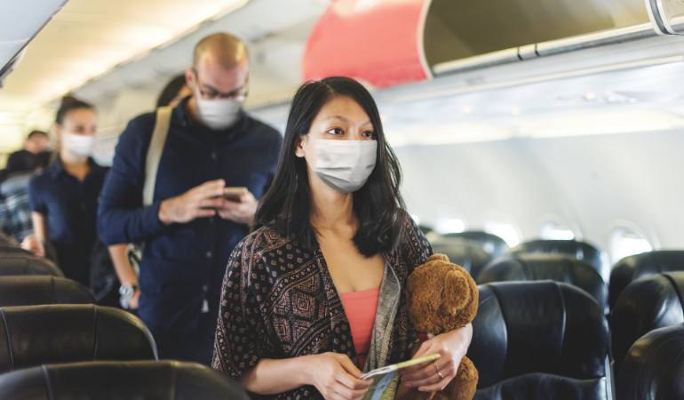 People getting off an airplane wearing masks