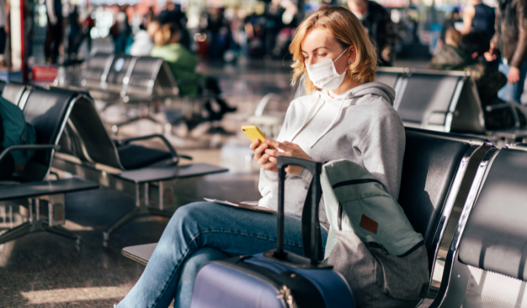 Woman wearing a mask and social distancing at the airport
